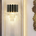 Modern black wall sconce with clear crystal vertical slats and dangling crystals for bedroom lighting