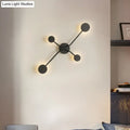 Modern black cross led wall lamp with four circular light fixtures in a symmetrical cross pattern for living room use