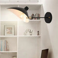 Modern black wall lamp with duckbill shade brass accents and curved arm bedroom sconce mounted on wall