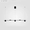 Modern black and gold ceiling light fixture featuring four minimalist cylindrical pendants for kitchen island lighting