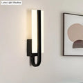 Modern black metal sconce light fixture with sleek curved design and glowing white warm light panel for living room