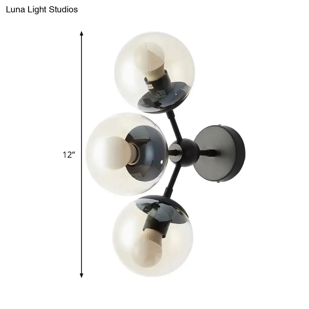 Modern black metal bathroom sconce with three clear glass spheres