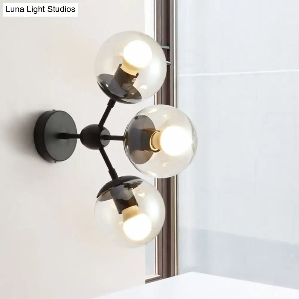 Modern black metal bathroom sconce with three clear glass spheres