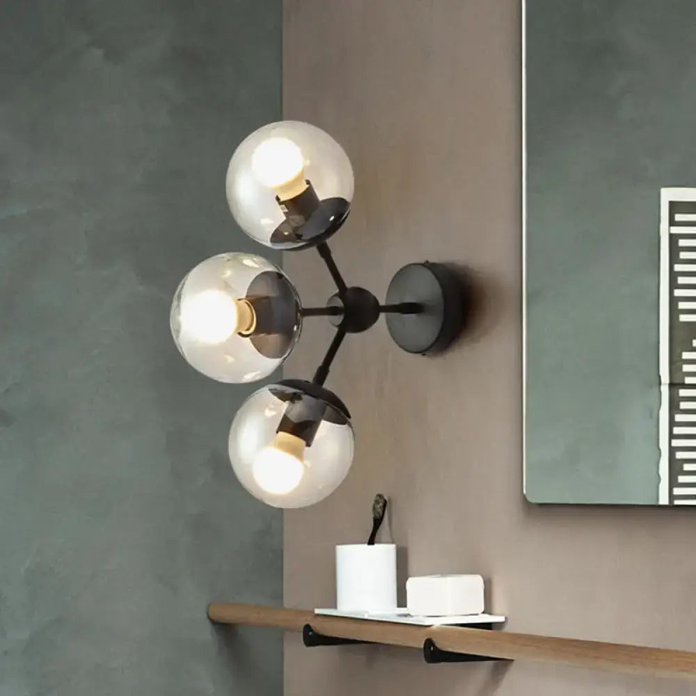 Modern black metal bathroom sconce with three clear glass spheres