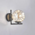 Modern black mini globe wall sconce with spherical glass globe and fairy lights showcasing fixture height in bedroom use