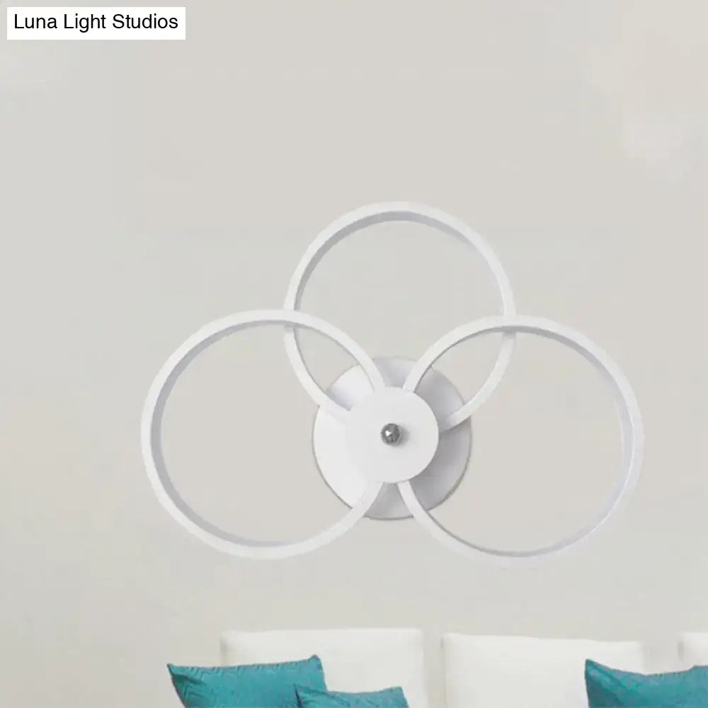 Modern black and silver led hoop wall lamp with three interlocking white circular rings for bedroom ceiling lighting