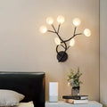 Modern black wrought iron wall light with six frosted glass globes in a tree branch design 24 inch fixture
