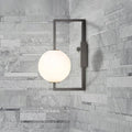 Modern black wall sconce with a frosted white glass orb shade ideal for bedroom lighting