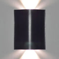 Modern black wavy wall washer lamp with sleek metallic finish and dual upward lights providing warm white lighting