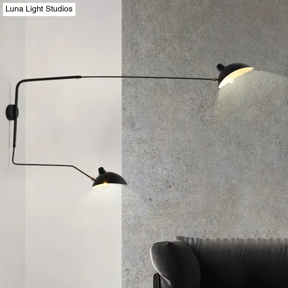 Black metal living room wall sconce with two articulated arms and dome-shaped shades light fixture