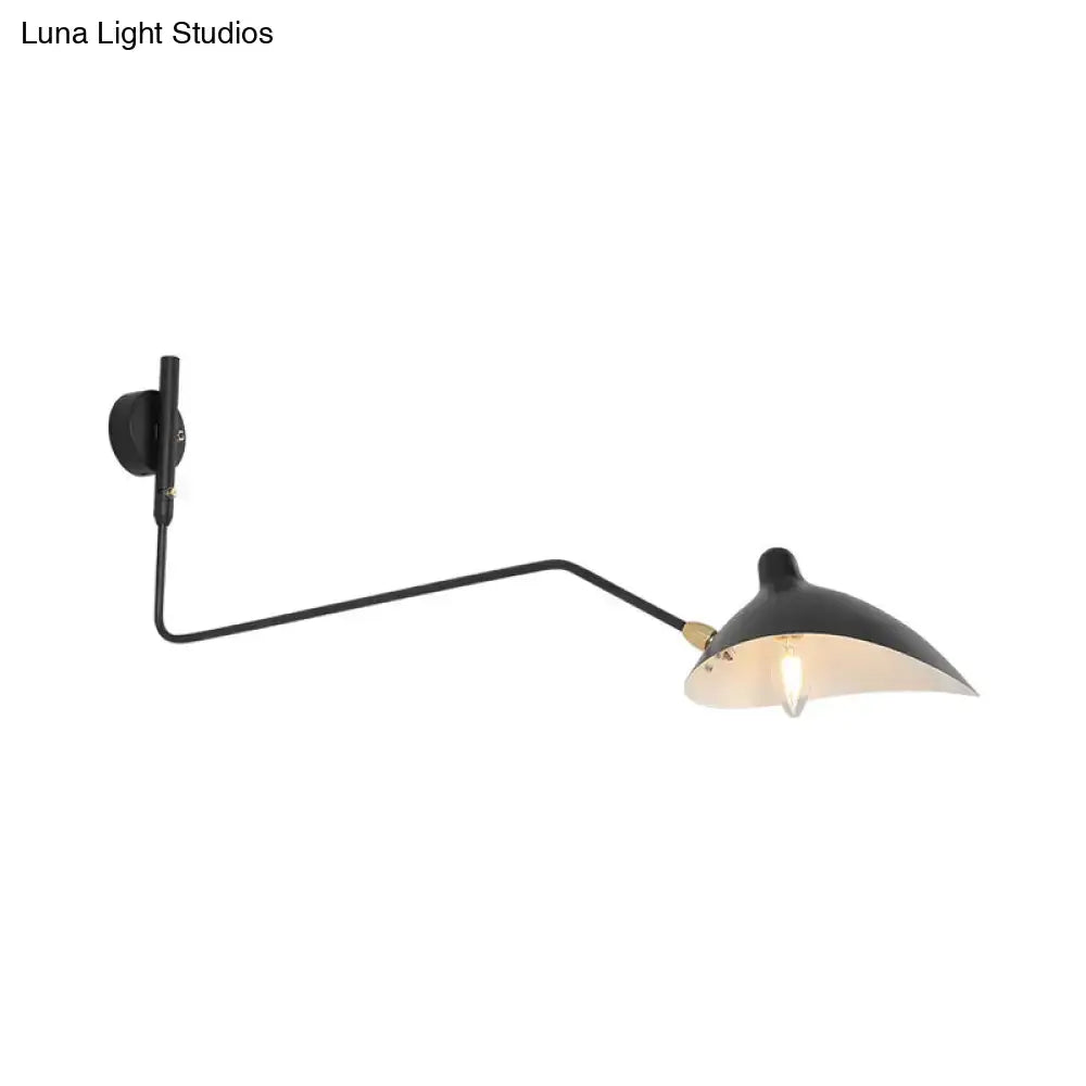 Modern black matte wall sconce with brass accents featuring a curved arm and conical shade living room light fixture