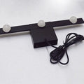 Modern black and white linear wall lighting with three frosted globe bulbs and a coiled power cord for warm white light