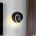 Modern black and white rotating eclipse wall lamp with sleek circular led sconce and illuminated ring accent for bedroom