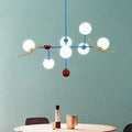 Modern blue and gold lamp fixture featuring opal glass ball shades and red accents for glass ball island dining room use