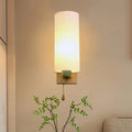 A warm modern brass wall lamp with opal glass shade and brushed base for 220v-240v bedroom use