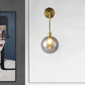 Modern brass and smoke gray glass corner wall light with smoked glass globe and exposed filament bulb bedroom sconce