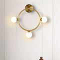 Modern brass circular wall light fixture with glass shades bedroom
