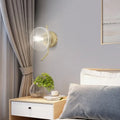 Modern brass glass dome wall sconce with gold arm and clear glass dome shade for bedroom lighting