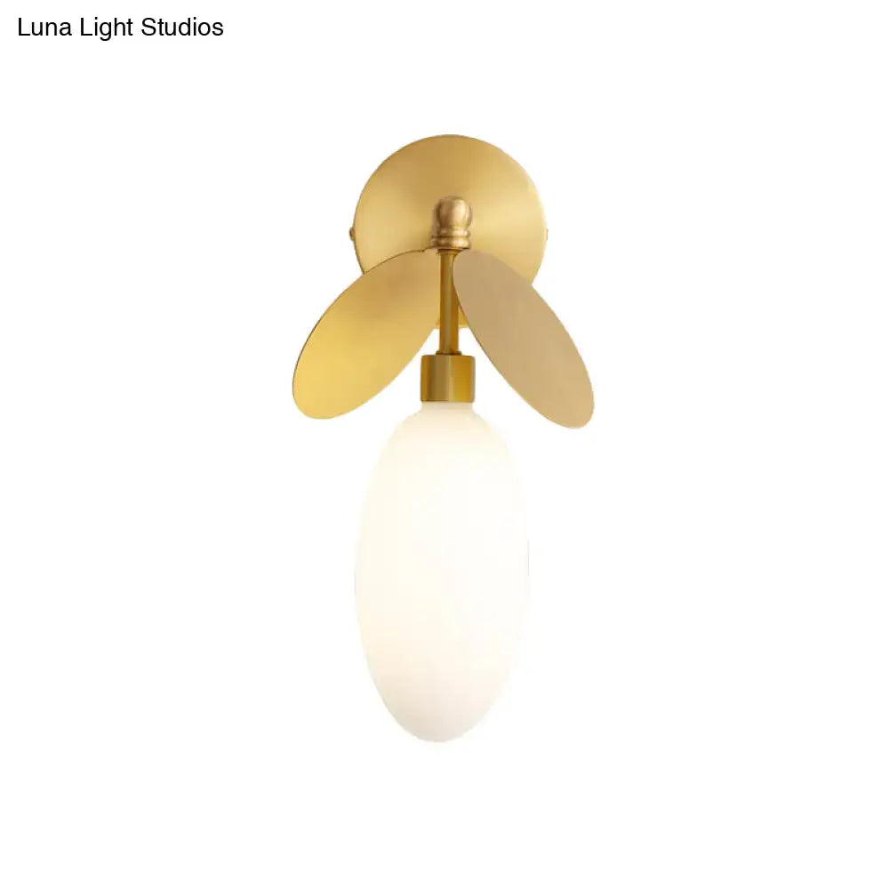 Modern brass leaf wall lamp with cream glass bedroom sconce