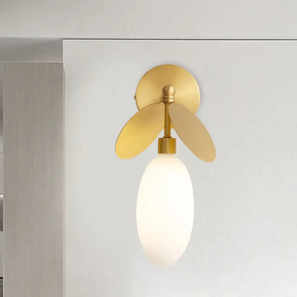Modern brass leaf wall lamp with cream glass bedroom sconce