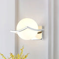 Modern chrome wall sconce with matte white glass globe and sleek curved metal accent for bedroom lighting