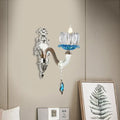 Elegant modern chrome finish wall light with clear glass candle holder and blue crystal accents for bedroom use