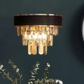 A modern sconce light fixture with black leather band, chrome trim, and cascading golden crystal block teardrops wall lamp