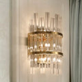 Gold-toned modern chrome gold crystal prism sconce wall lamp with vertical crystal rods and circular metallic bands for living room