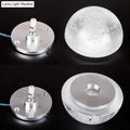 Modern wall light with clear bubble crystal textured dome and silver base emitting warm white light for living room use