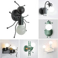 Black metal ant-shaped wall sconce with articulated legs and exposed bulb showcasing modern creative minimalism design
