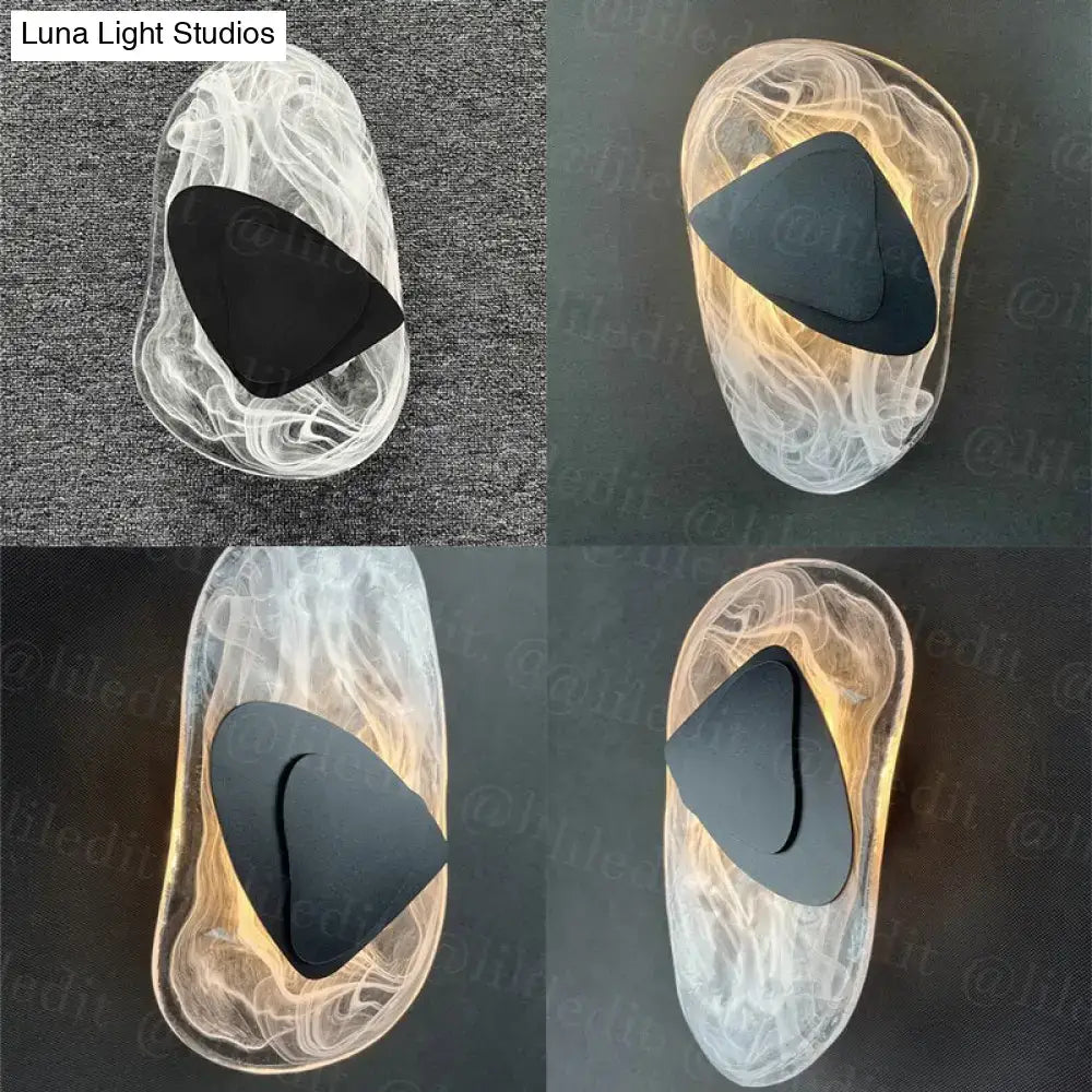 Modern creative minimalist wall lamp with translucent swirling glass body and sleek black triangular backplate for bedside lighting