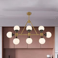 Modern gold decorbites metal chandelier with six frosted glass globe shades and black accents for island lighting