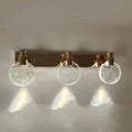 Modern gold crystal led wall lamp with three circular glass globes filled with sparkling particles for bathroom use