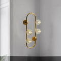 Modern gold wall lamp with five faceted crystal shade globes on a curved frame direct wired electric fixture