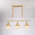 Gold-toned DecorBites™ crystal teardrop island pendant light with gold cylinder and three ornate crystal pendant heads