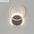 Modern gold dual ring led wall sconce with two concentric circular rings emitting a warm glow for bedroom lighting