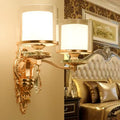 Modern gold ornate wall lamp with frosted glass shades and crystal droplets creating an inviting glow