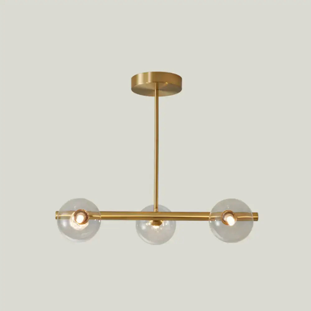 Modern gold island pendant lighting with three clear glass globe shades and minimalist metal arms for dining room