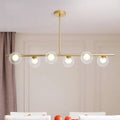Modern gold linear island light fixture with five clear glass globe shades brass island light fixture