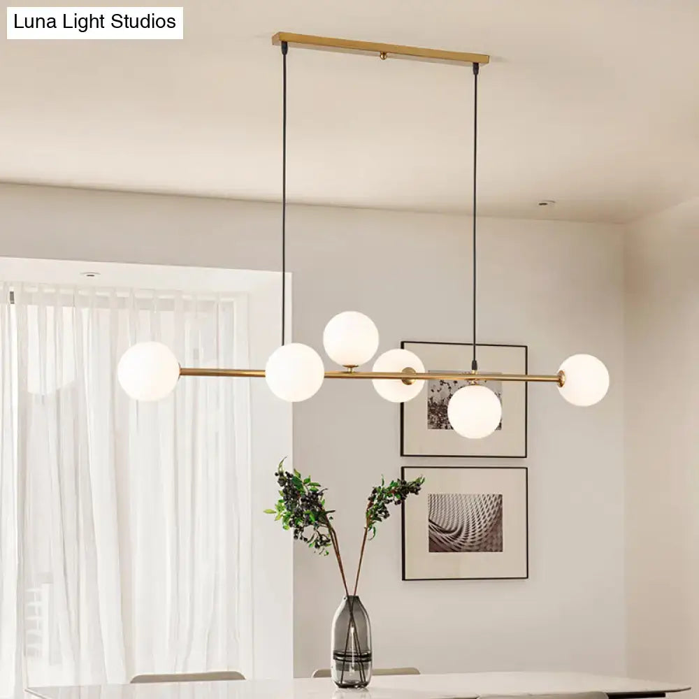 Modern gold metal island pendant with blue glass spheres dining room