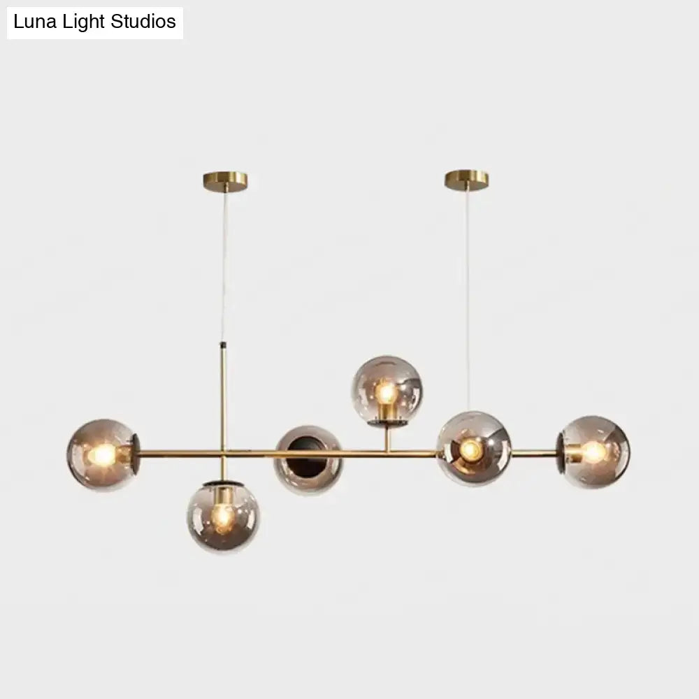 Modern gold metal island pendant with blue glass spheres dining room