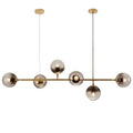 Modern gold metal pendant lighting featuring brass and smoked glass spherical bulbs for dining room use