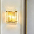 Modern gold wall sconce featuring vertical clear crystal rods designed for elegant hallway lighting