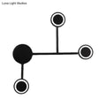 Modern led black wall sconce coat rack with four circular warm white hooks mounted on a minimalist black wall