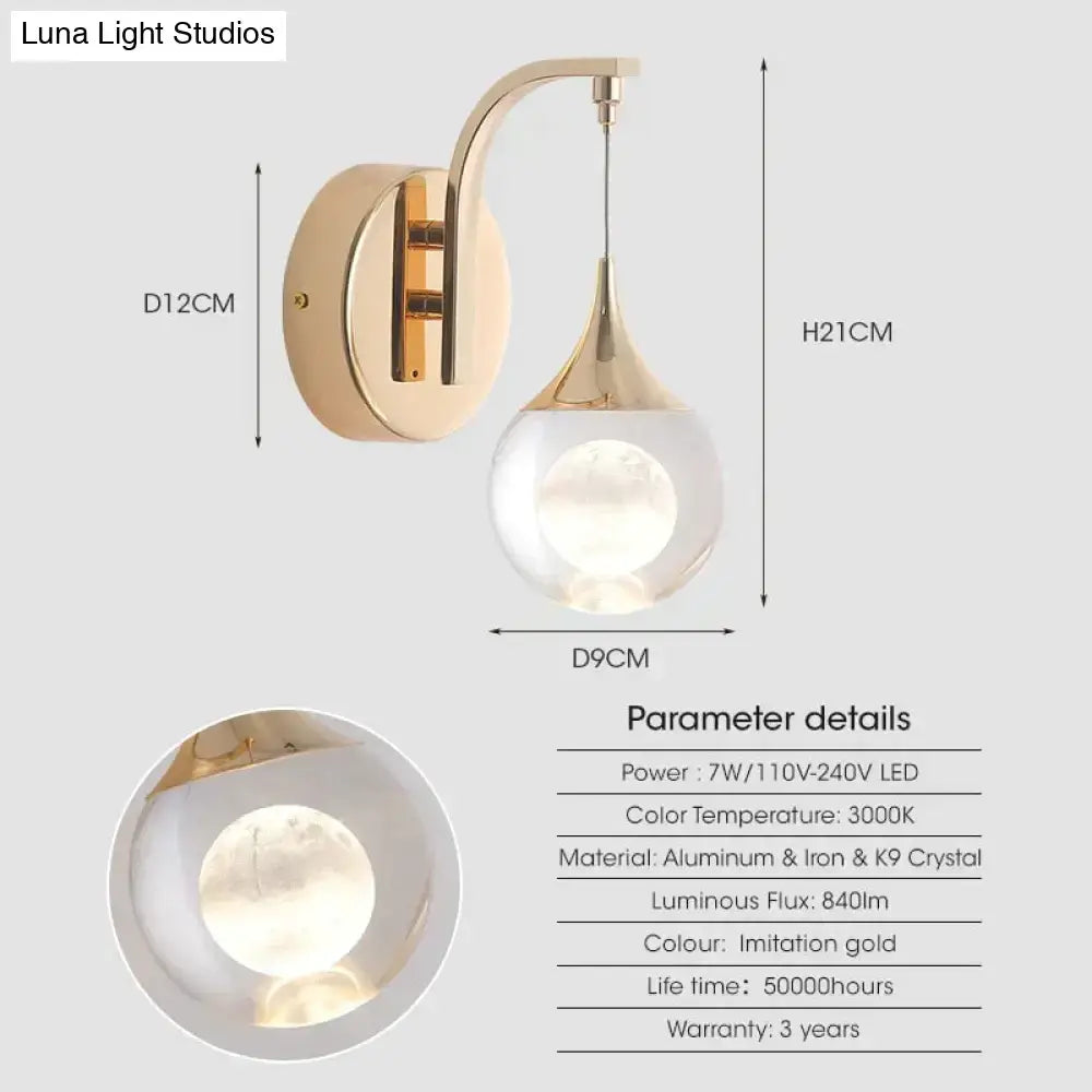 Modern luxurious crystal led wall sconce with a gold curved lamp and teardrop glass globe for bedroom lighting