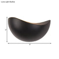 A sleek matte black ceramic bowl with a crescent shape used in modern metallic wall washer bedroom sconce lighting