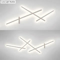 Modern minimalist white wall lamp with crossed linear arms and soft white LED glow for living room use