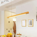 Modern minimalist wood linear island pendant light with sleek wooden frame and warm led strip ambient glow