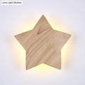 A warm glowing modern natural wood star wall lamp with visible grain designed for living room sconce lighting