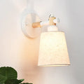 Modern Nordic wood wall lamp with white circular base, light wood arm, beige horn shade for bedroom sconce lighting